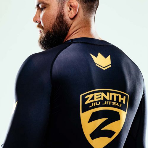 robert drysdale stands with his back to the camera looking over his left shoulder - the zenith jiu jitsu logo is on his back