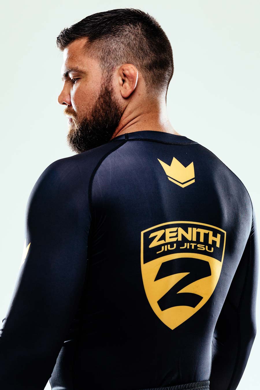 robert drysdale stands with his back to the camera looking over his left shoulder - the zenith jiu jitsu logo is on his back