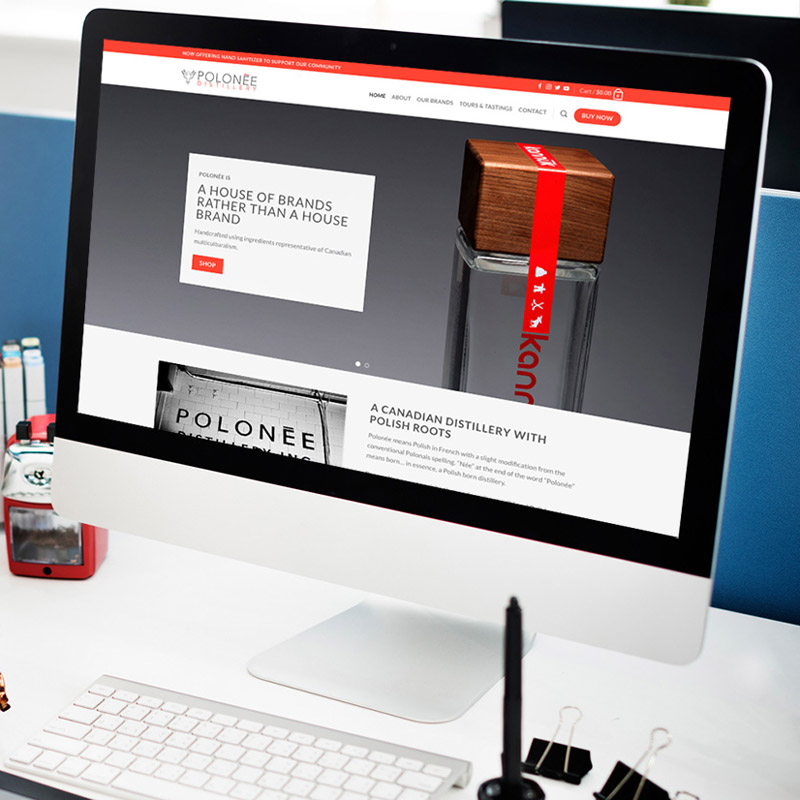 an apple imac sits on a desk displaying the polonee distillery website project