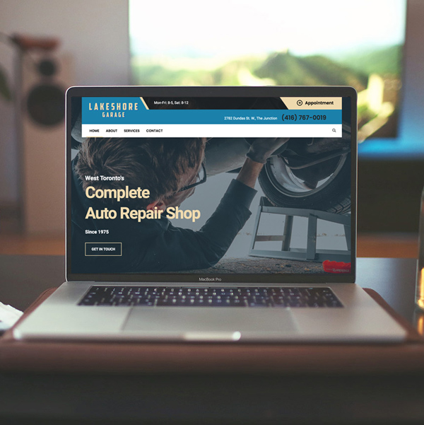 a desk with a laptop displaying the lakeshore garage website