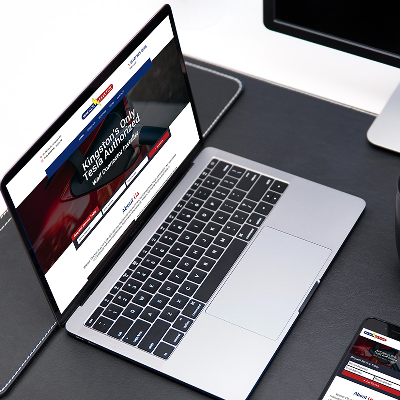 a laptop sits on a desk displaying the wieser electric website