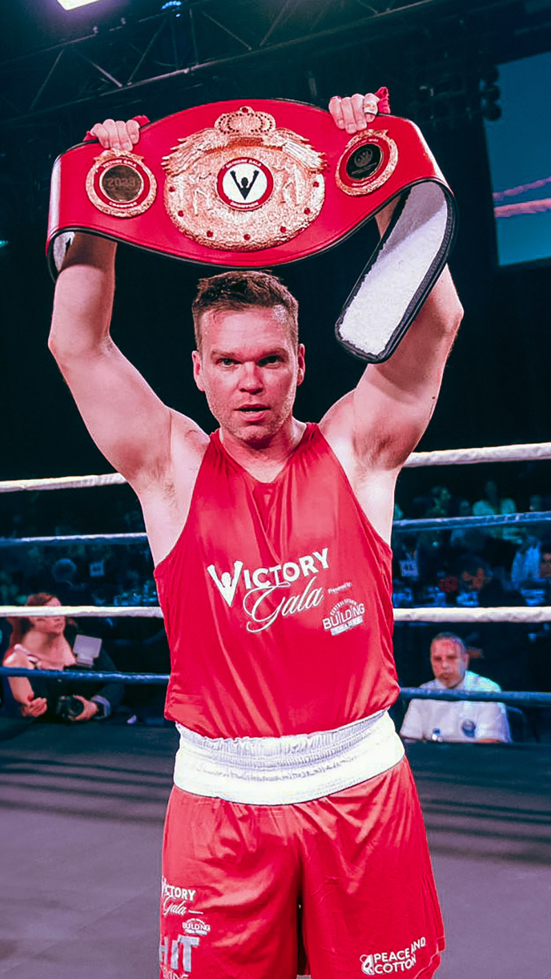 dave mcgregor is shown holding a boxing title belt above his head